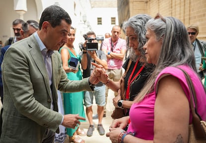 El presidente andaluz, Juan Manuel Moreno, habla con dos madres con hijos en cuidados paliativos, este jueves en el Parlamento. 