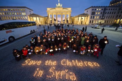 Un grupo de personas forma, con velas, la frase &quot;Salvad a los ni&ntilde;os de Siria&quot;, ayer en la puerta de Brandenburgo en Berl&iacute;n. 