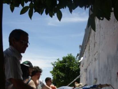 Unos vecinos encalan el muro del polideportivo en Higuera de la Serena.