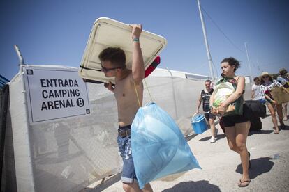 Algunos asistentes transportan su equipaje dentro del camping Arenal, en Burriana, Castellón.