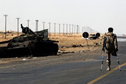 Un rebelde camina junto a las líneas del frente en la entrada oeste de Ajdabiya.