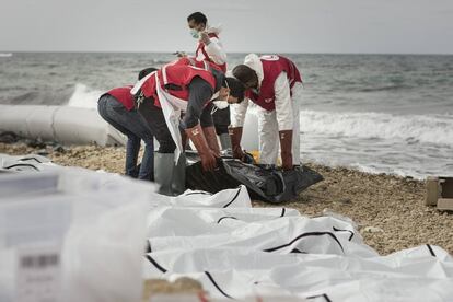 Cooperantes libios de la Media Luna Roja mueven el cuerpo de uno de los fallecidos frente a las playas de la ciudad de Zauiya.