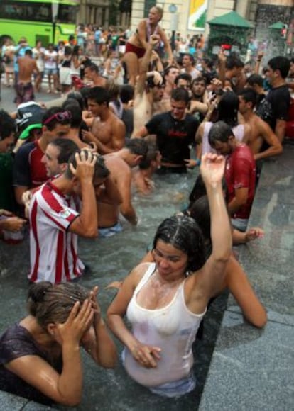 Varios jóvenes se refrescan y limpian después del 'txupinazo'.