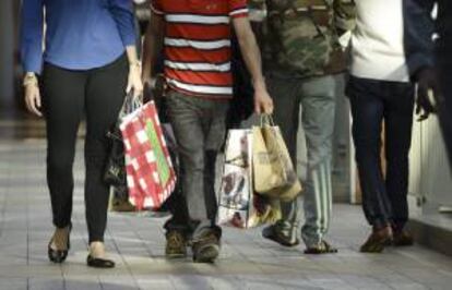 Un grupo de personas pasea con las compras realizadas en el día del 'viernes negro' por el centro comercial de Lenox, en Atlanta, Georgia. EFE/Archivo