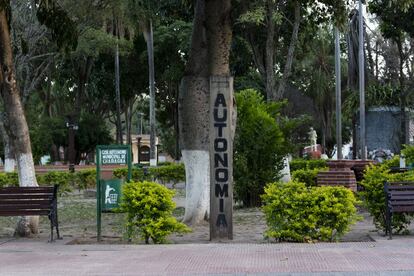 Un poste pintado anuncia la recién adquirida autonomía en la plaza central de Charagua, mientras que la papelera aún mantiene la identificación del gobierno municipal.