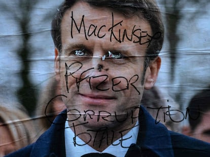 Un cartel electoral de Emmanuel Macron sobreescrito con el mensaje "Mac Kinsey, Pfizer, corrupción total", este domingo en París.