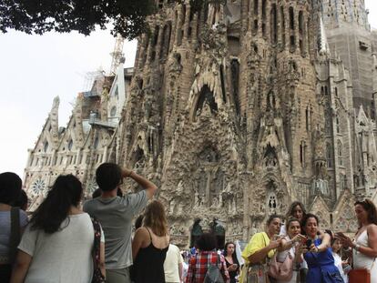 Grupos de turistas frente a la Sagrada Familia en Barcelona.