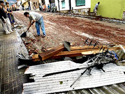 Vecinos  de Centelles limpian el barro y los cascotes de la calle tras la turbonada que ayer afectó el sur de Osona.