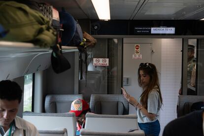 una mujer se acerca a su asiento en el primer viaje del Tren Maya, en el tramo Campeche-Cancún.