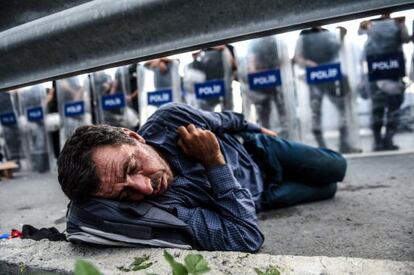 Un refugiado duerme ante un cordón de la policía antidisturbios turca, que ha bloqueado la carretera en dirección a Edirne, en Estambul.