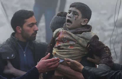 Un niño herido rescatado de entre los escombros de su vivienda destruida en el ataque aereo.