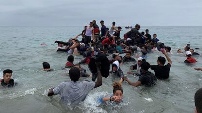 Um grupo se apropria de uma embarcação das autoridades marroquinas na praia da localidade de Fnideq para atravessar os quebra-mares de Ceuta, na terça-feira. Em vídeo, imagens das chegadas em balsas improvisadas nesta quarta.
