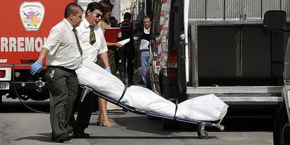 Trabajadores de la funeraria trasladan el cuerpo del hombre que falleció ayer en un tiroreo.