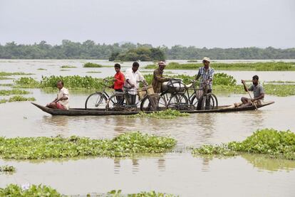 Moradores do distrito de Morigaon (Índia), afetado pelas inundações de agosto de 2014, transportam suas bicicletas em canoas.