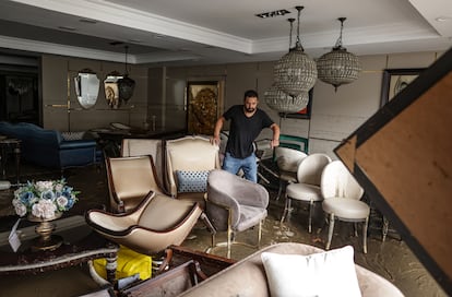 Un hombre se abre paso en una tienda de muebles inundada en Estambul, Turquía.  