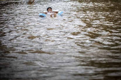 Según las autoridades, la cifra de los 31.000 evacuados no incluye a los habitantes de las localidades lindantes con la capital. En la imagen, un joven flota en una calle inundada de Yakarta.