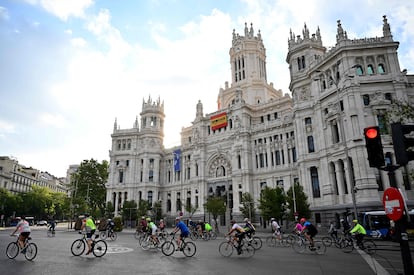 Un grupo de ciclistas circula por delante del Ayuntamiento de Madrid en la plaza de Cibeles, esta mañana.