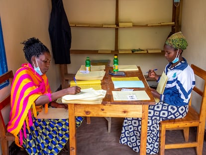 Dos mujeres del personal de oficina realizan la contabilidad de los ingresos de la cooperativa de productores de café de Abakundakawa, estación de lavado de café de Minazi, distrito de Gakenke, Ruanda.