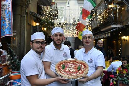 Tres 'pizzaioli' posen a Nàpols amb una pizza, per celebrar la seva inclusió en el Patrimoni Immaterial de la Unesco.