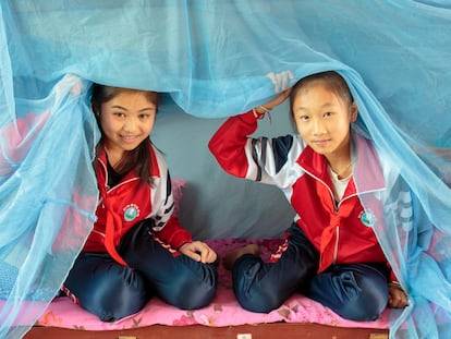 Dos estudiantes del internado Friendship Primary School, de la provincia china de Yunnan muestran las redes mosquiteras con las que se protegen del mosquito que transmite la malaria.
