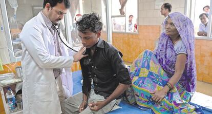 Un m&eacute;dico atiende a un paciente en Nueva Delhi (India).