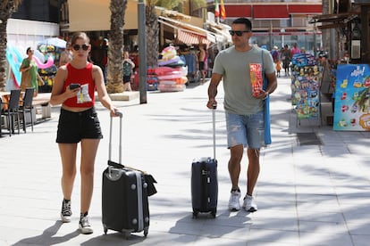 Dos turistas transitan una calle de Torrevieja, en Alicante, una de las localidades donde más propietarios alquilan en verano.