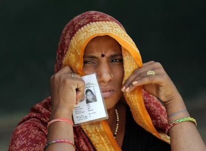 Una mujer muestra su tarjeta de identidad antes de votar en los alrededores de Benarés.