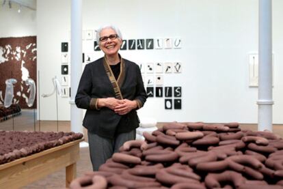 Anna Maria Maiolino en la Fundación Tàpies, junto a una de sus instalaciones de barro crudo.