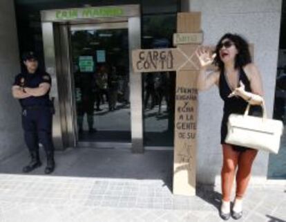 Un policía custodia una oficina de Bankia