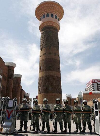 Soldados pertrechados con material antidisturbios controlan el acceso a la mezquita de Urumqi.