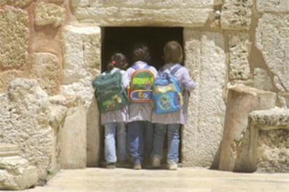 Tres niñas palestinas echan un vistazo a la basílica de la Natividad desde la Puerta de la Humillación.