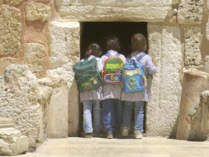 Tres niñas palestinas echan un vistazo a la basílica de la Natividad desde la Puerta de la Humillación.