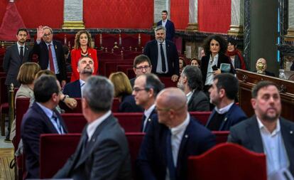 Catalan premier Quim Torra waves at the defendants inside the Supreme Court.