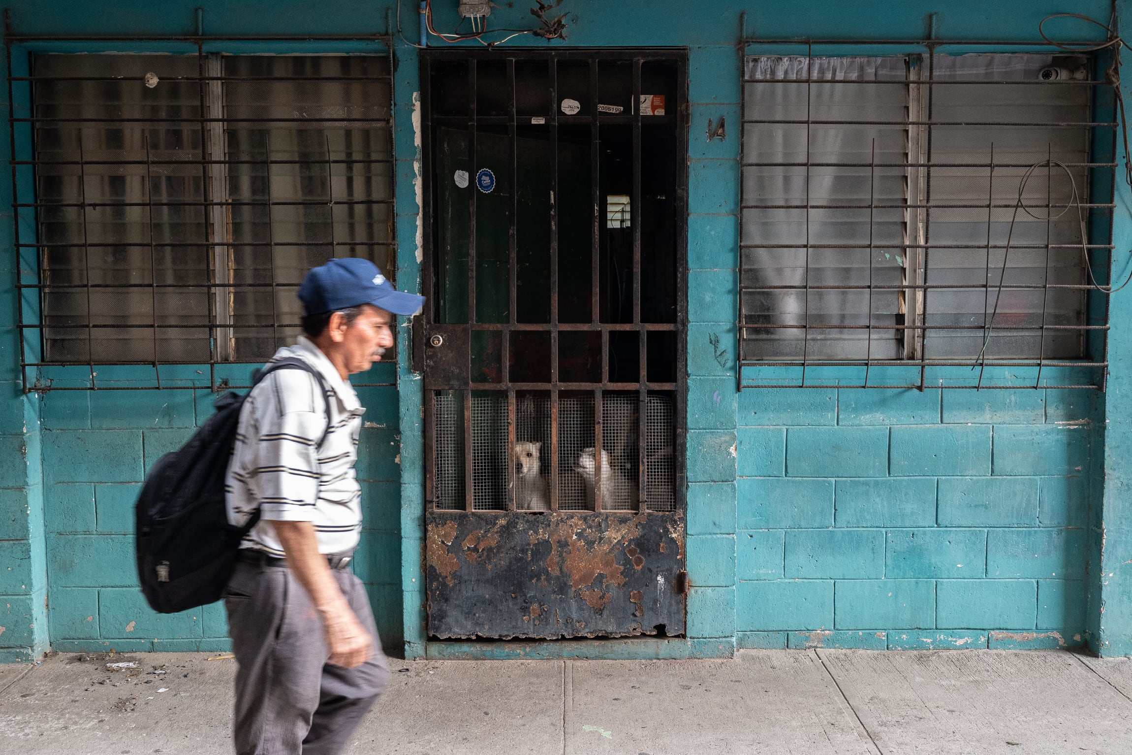 Las rejas metálicas de seguridad en las puertas de entrada de los apartamentos de Zacamil, un recordatorio de la reciente historia de violencia del barrio, marcada tanto por el conflicto armado de 1980-1992 como, posteriormente, por la presencia de la banda Barrio 18. Fotografía tomada en San Salvador, el 25 de abril de 2026.