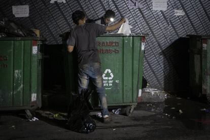 Dos jóvenes buscan plástico en unos contenedores de basura. La recolección de plástico para su posterior venta a empresas de reciclaje es una de las pocas salidas económicas que tienen muchas familias en Beirut.
