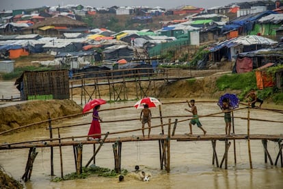 En Bangladesh, alrededpr de 21.000 rohingyas que se encontraban en campos para refugiados tuvieron que ser reubicados debido a las inundaciones. Cinco niños fallecieron al quedar aplastados por un desprendimiento del terreno cerca de Cox Bazar. En la imagen, varios niños caminan por un puente en Cox Bazar, el 13 de junio de 2018.
