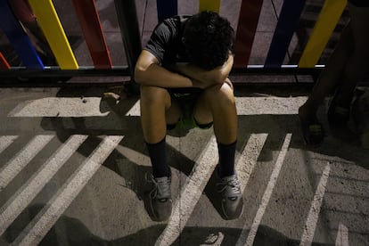 Ayman, de 16 años, se queda dormido apoyado en la valla de un parque infantil de Ceuta.