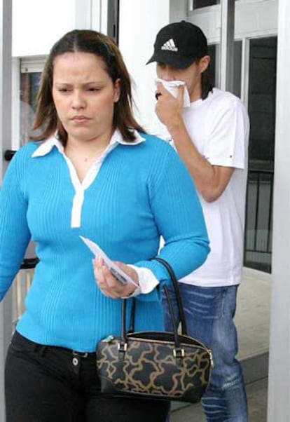 Juan Arango (detrás), junto a su esposa (en primer término), a la salida del hospital.