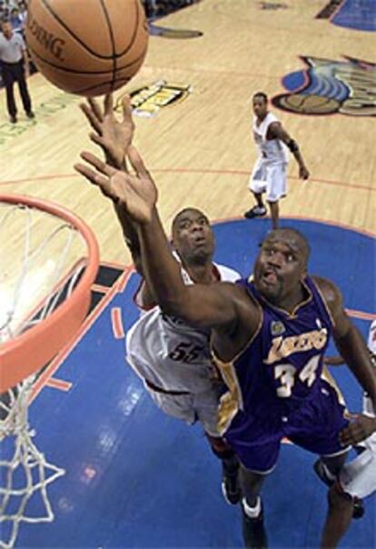 Shaquille O'Neal y Dikembe Mutombo luchan por un rebote en el tercer partido de la final.