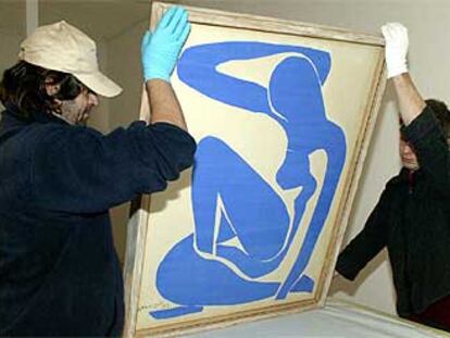 Dos operarios colocan <i> Desnudo azul IV</i> (1952), de Henri Matisse, en la Galería de Arte Moderno de Bolonia.