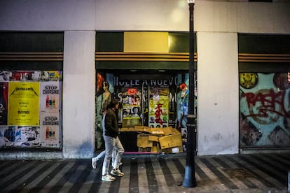 Una pareja pasa este sábado delante de una persona sin hogar que duerme en los aledaños a Gran Vía. 