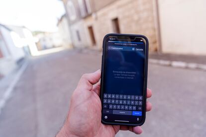 Un paseante muestra su teléfono sin cobertura en una calle de Castronuevo de Esgueva.

