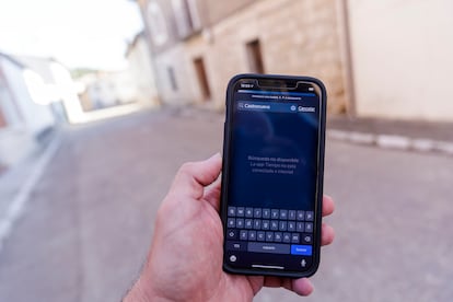 Un paseante muestra su teléfono sin cobertura en una calle de Castronuevo de Esgueva.

