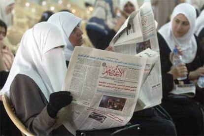 Mujeres iraquíes leen periódicos que informan sobre el juicio a los soldados estadounidenses.