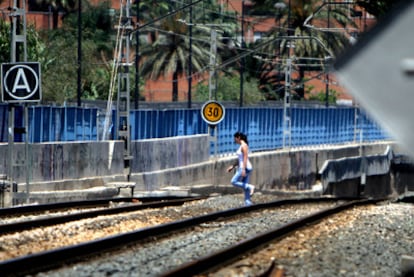 Una chica cruza las vías del tren el lunes a mediodía a su paso por el Camino de las Moreras, junto al barrio de Natzaret en Valencia. Ocurre continuamente.