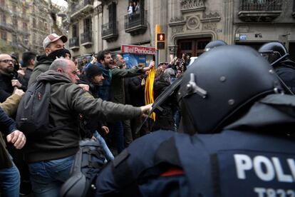 Manifestants s'enfronten a la policia antiavalots que bloqueja la cruïlla del carrer Mallorca amb Roger de Llúria, davant la seu del Govern espanyol a Barcelona.