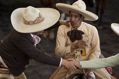 Dos charros beben y saludan a amigos durante la charreada celebrada en México. Pese a que ganar siempre es un honor, asegura Manuel Basurto Rojas, presidente de la Asociación Nacional de Charros, lo más importante de estas infrecuentes competiciones es la convivencia. "Es una oportunidad de pasar tiempo con todos nuestros hermanos charros de toda la República Mexicana".