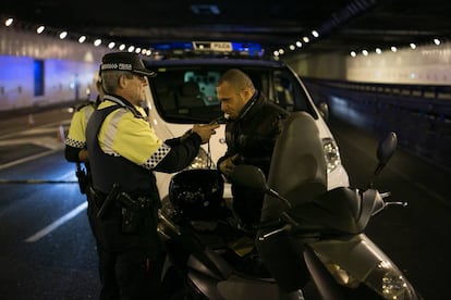 Un agente de la Guardia Urbana de Barcelona hace la prueba de alcoholemia a un motorista, en diciembre pasado. 