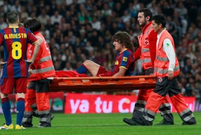 Puyol sale en camilla tras lesionarse ante el Real Madrid.