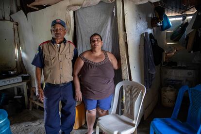 En las paredes rosadas de la vivienda de Quisqueya Estevez está la marca "MF 032". La casa sigue a la espera de ser demolida, aunque la sección en la que estaba el baño cedió por un deslizamiento de tierra por las obras. Estevez niega haber sido indemnizada por las autoridades. En la imagen, Quisqueya Estevez y Antonio Ramírez posan para un retrato, al interior de su vivienda en Dajabón.